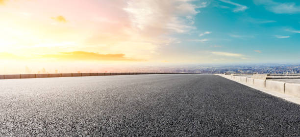 istock Panoramic city skyline and buildings with empty road at sunset 1071602984