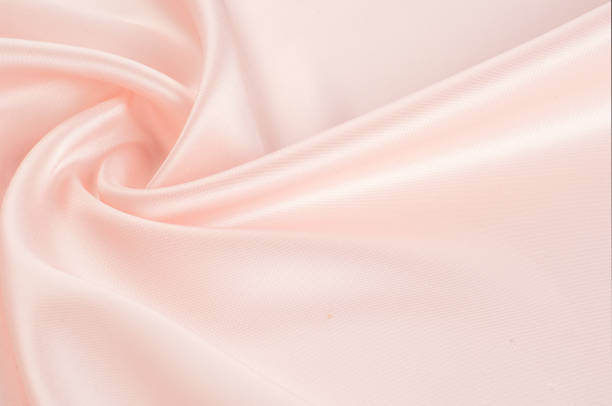 istock Texture, background, pattern. Fabric silk pink background. Beautiful pink satin. Drapery background. winds waves, creating a beautiful background of the folds. 1071608156