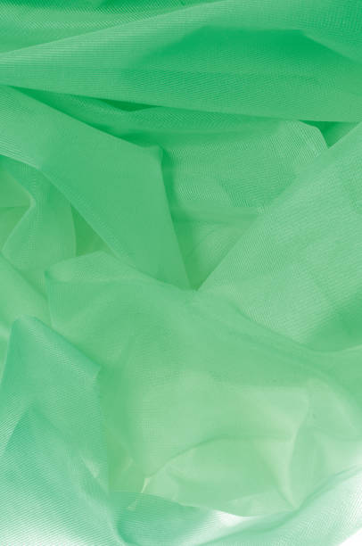 istock Texture, background, pattern. The texture of the silk fabric is green. Silk fabric is transparent. Fabric or liquid wave illustration of wavy creases of silk satin texture or velvet material 1071608232