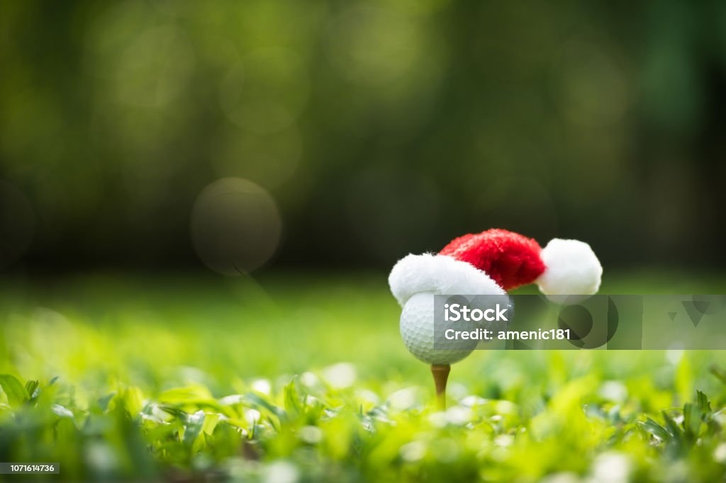 Festivo-mirar la pelota de golf en tee con sombrero de Santa Claus en la parte superior - Foto de stock de Golf libre de derechos