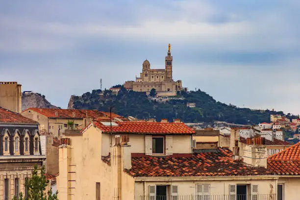 Photo of City rooftops and Notre-Dame de la Garde Catholic basilica on the hill, city's best-known symbol and site of a popular Assumption Day pilgrimage, the most visited site in Marseille, France