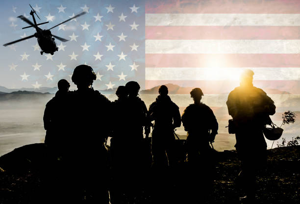 silhouettes of soldiers during military mission against american flag background - flag of afghanistan imagens e fotografias de stock