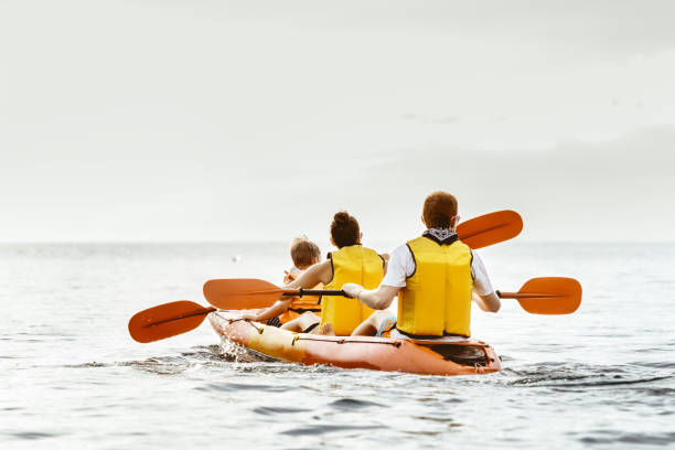 familie mit sohn kayaking meer konzept - sailing nautical vessel family lake stock-fotos und bilder