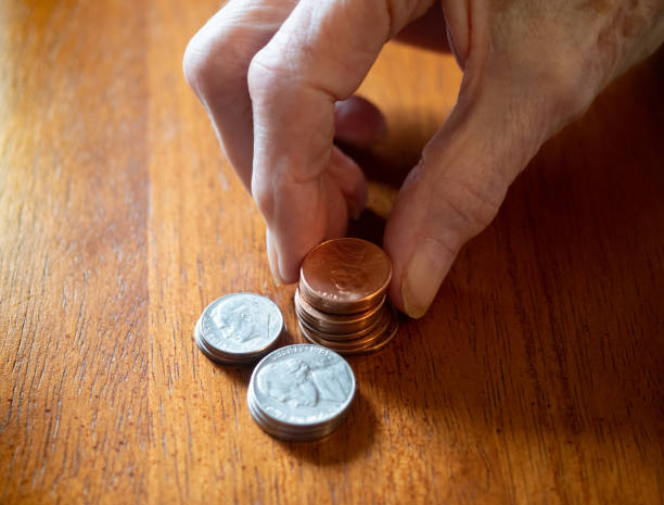 mulher idosa mãos empilhamento moedas de estados unidos - coin stacking nickel penny - fotografias e filmes do acervo