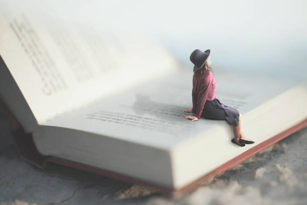 surreal moment of a woman relaxes sitting on a giant book surreal moment of a woman relaxes sitting on a giant book giant fictional character stock pictures, royalty-free photos & images