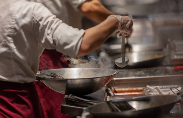 istock Chef pouring ingredients in to wok 1071656880