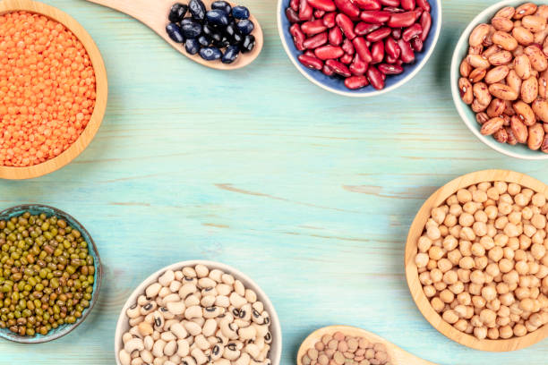 istock Legumes, shot from above on a teal blue background, forming a frame with a place for text. Red kidney and pinto beans, lentils, chickpeas, soybeans, black-eyed peas with copy space 1071657136