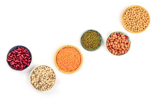 Legumes, shot from the top on a white background with copy space. Red kidney and pinto beans, lentils, chickpeas, soybeans, black eyed peas in bowls with a place for text Legumes, shot from the top on a white background with copy space. Red kidney and pinto beans, lentils, chickpeas, soybeans, black eyed peas in bowls with a place for text red mung bean stock pictures, royalty-free photos & images