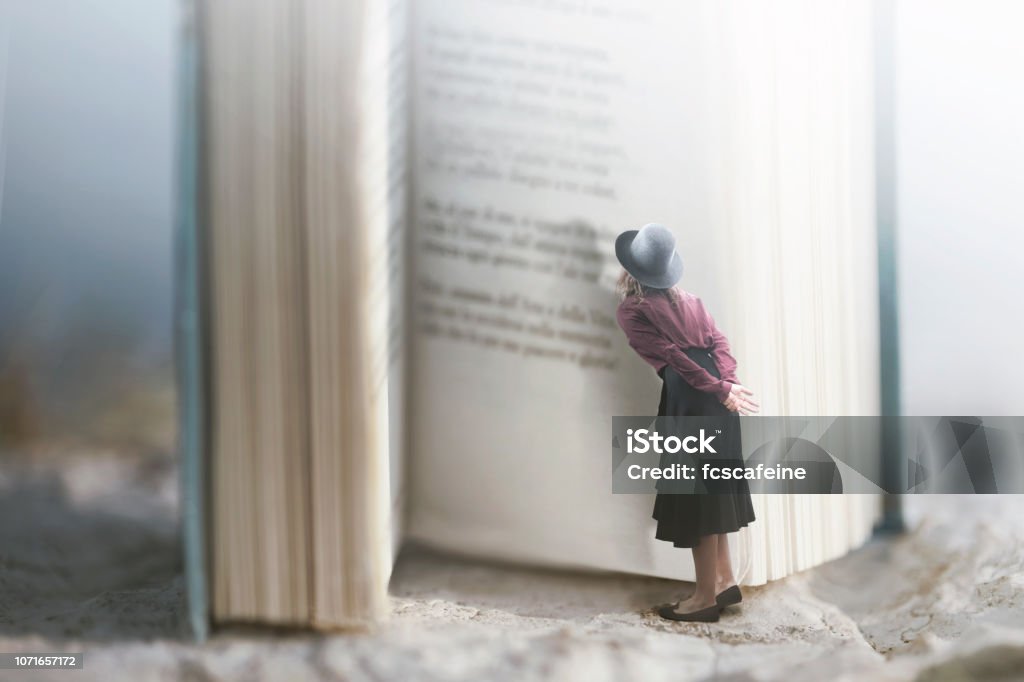 Curious woman reads a giant book Book Stock Photo