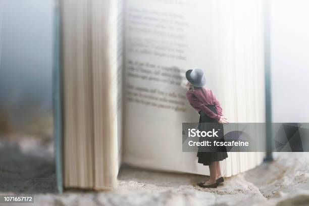 Curious Woman Reads A Giant Book Stock Photo - Download Image Now - Book, Fairy Tale, Surreal