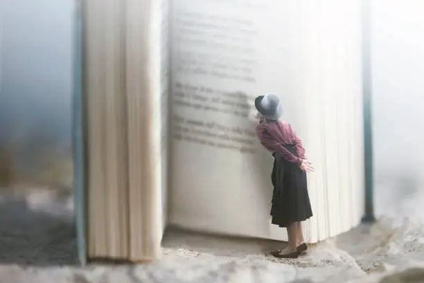 Photo of Curious woman reads a giant book