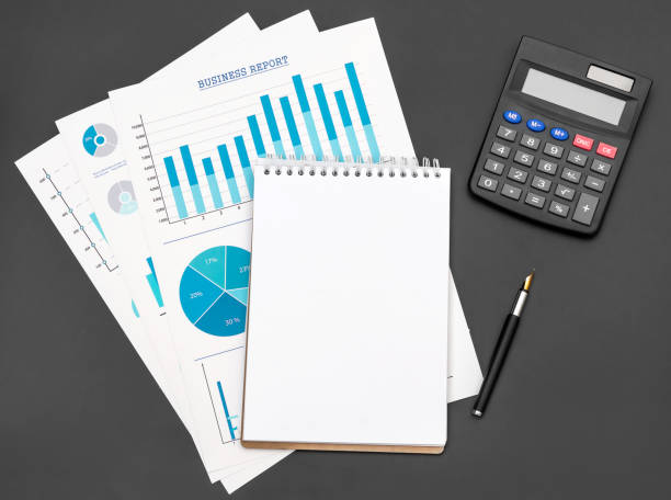 istock Financial graphs with notepad and calculator on black background. Top view. Space for text. 1071666234