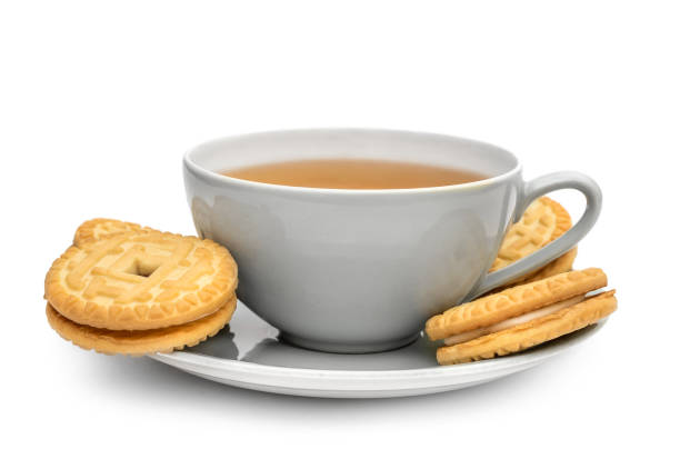 tazza di tè con biscotti sandwich su piattino. isolato su bianco. - tea cakes foto e immagini stock