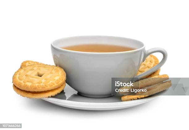 Cup Of Tea With Sandwich Cookies On On Saucer Isolated On White Stock Photo - Download Image Now