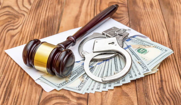 istock Gavel and handcuffs on the envelope with money. 1071666860
