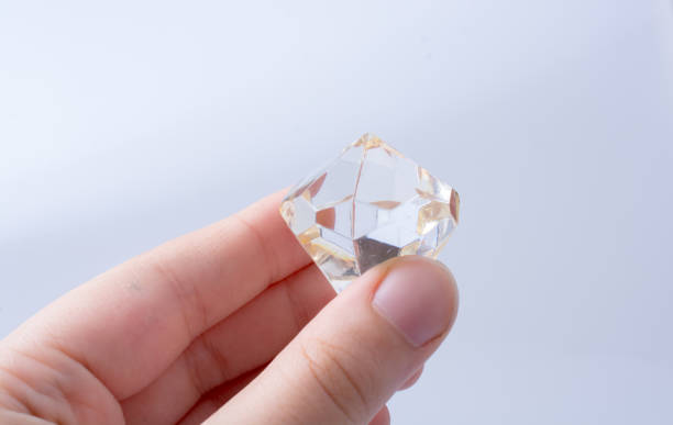 istock Hand holding a transparent diamond on white background 1071678928