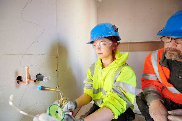 stagiaire de plomberie féminin au collège - trainee education construction worker plumber photos et images de collection