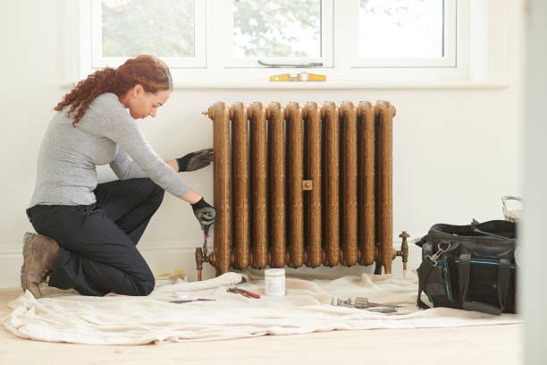 istock female plumber installing cast iron radiator 1071685008