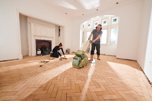 two workers repair and restore a parquet period floor