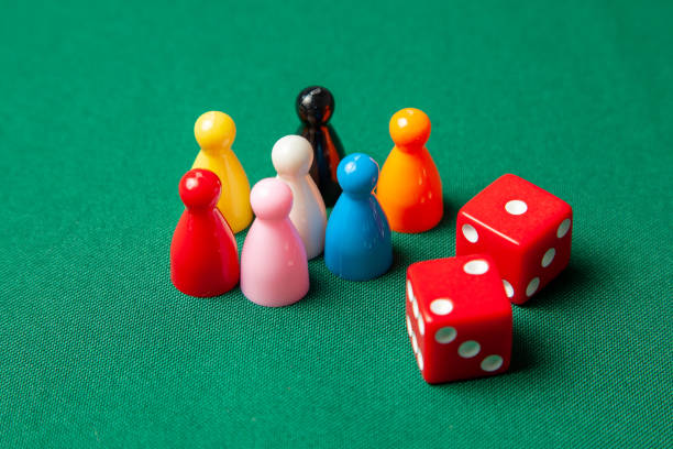 istock Colored game figures chips for board games. Collection of dice cubes on green table 1071692116