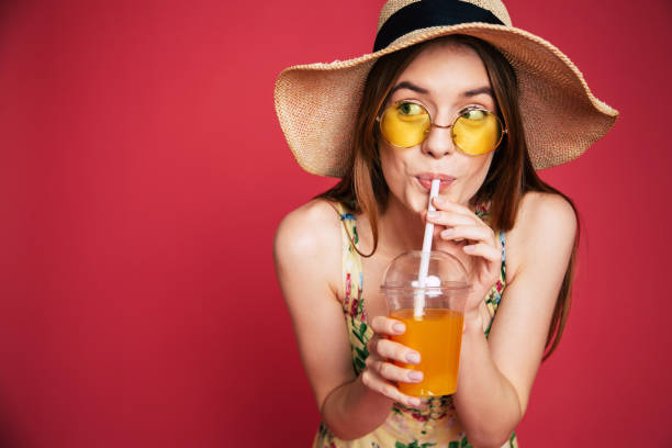 istock Happy woman with juice in summer hat 1071692128