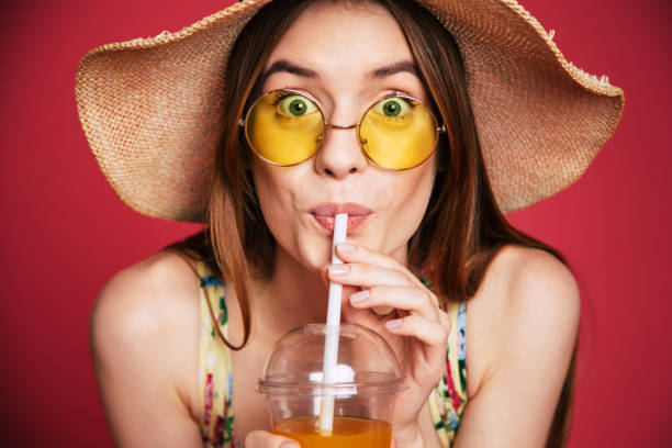 istock Happy woman with juice in summer hat 1071692134