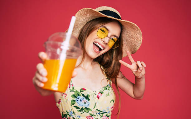 istock Happy woman with juice in summer hat 1071692146
