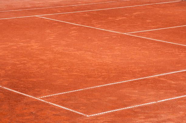 Part of red clay tennis court surface Part of empty used red clay tennis court playground surface with white lines closeup clay court stock pictures, royalty-free photos & images