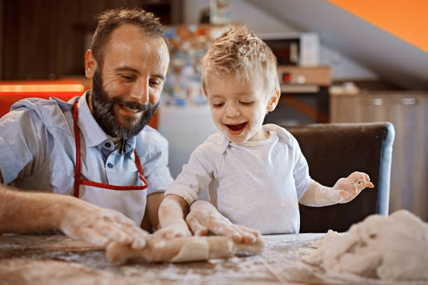 istock Cute little baker and his father making a bread 1071694248