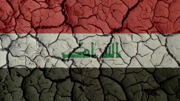 Political Crisis Or Environmental Concept: Mud Cracks With Iraq Flag