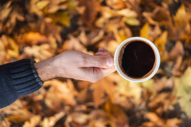 istock Autumn leafs and coffee cup on wooden table. 1071712036
