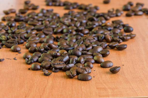 istock Coffee grains lying on a wooden background. 1071714536