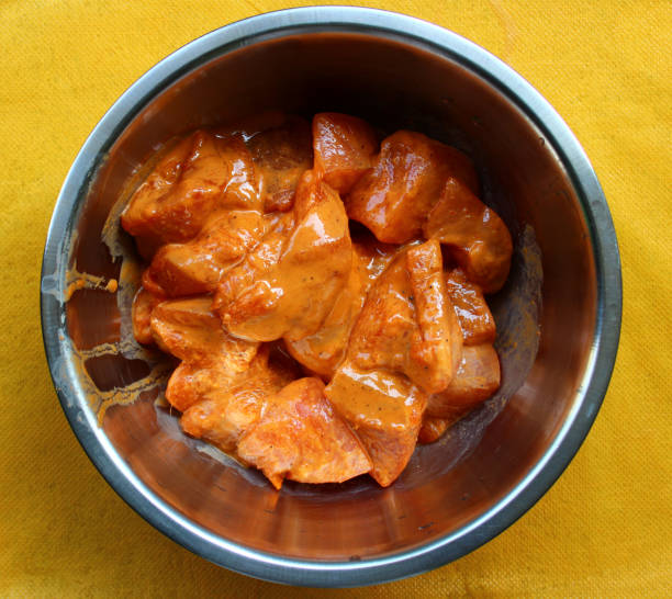 Marinated chicken pieces Marinated boneless chicken pieces for preparing chicken tikka inside a steel bowl marinade stock pictures, royalty-free photos & images