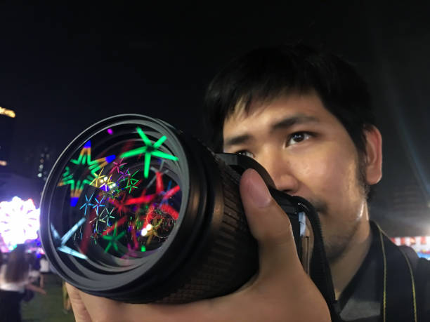 fotocamera maschio che tiene la mano che hanno riflettono bella luce sull'obiettivo - riflesso sullobiettivo foto e immagini stock