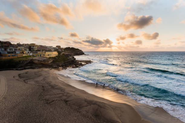 istock Sunrise with two swimmers in waves 1071717762