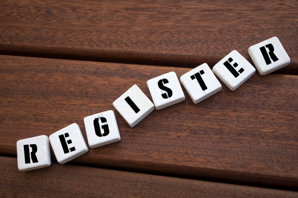 istock REGISTER Concept with alphabet blocks on wooden table. 1071717906