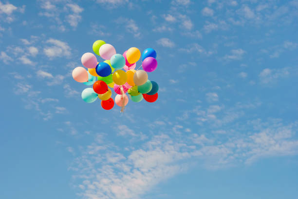 istock flying colorful toy balloon on a blue sky 1071719104