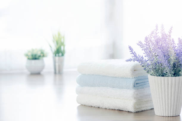 istock Mockup stack of white towels and houseplant on white table with copy space. 1071719236