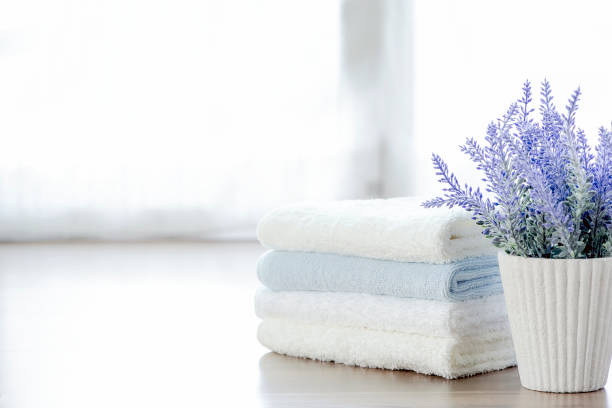 istock Mockup stack of  towels and houseplant on white table with copy space. 1071719428