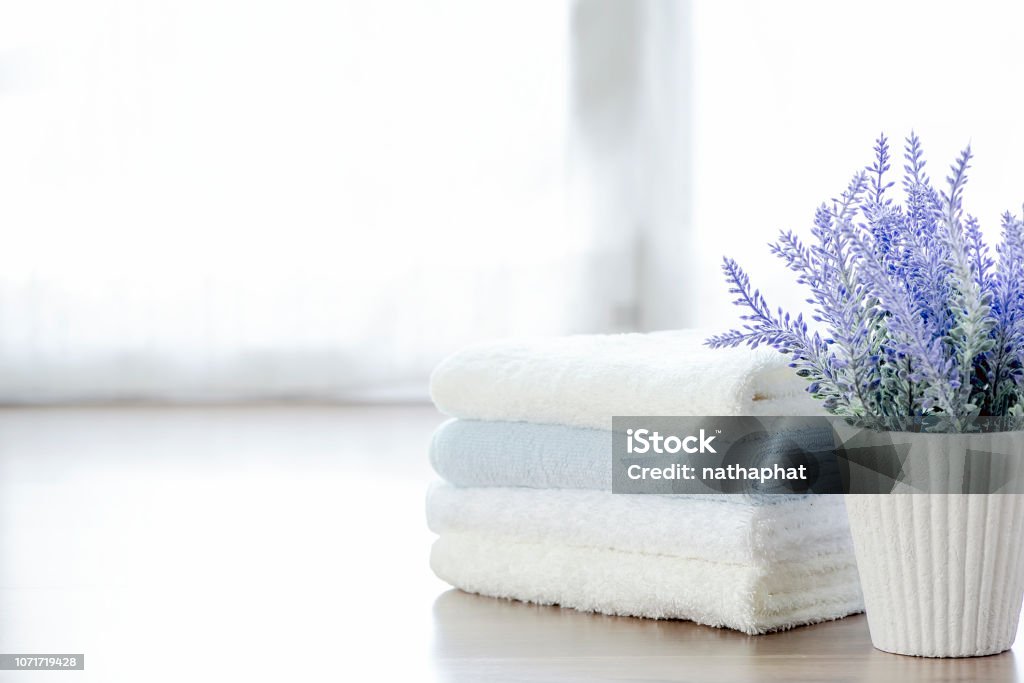 Mockup stack of  towels and houseplant on white table with copy space. Mockup stack of white towels and houseplant on white table with copy space. Bathroom Stock Photo