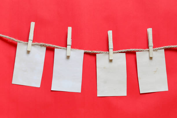 istock Blank brown note on clothesline and red background. 1071724784