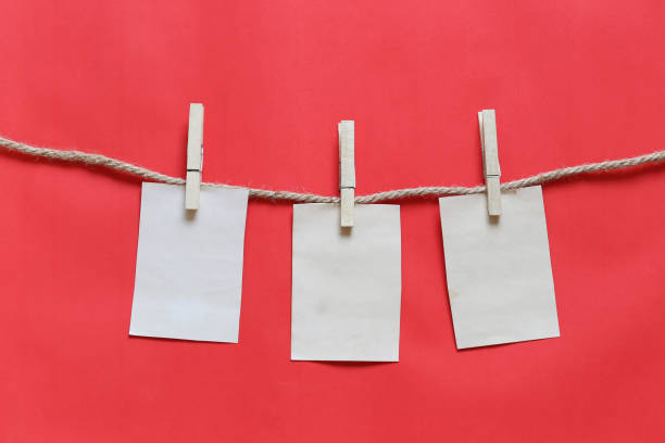 istock Blank brown note on clothesline and red background. 1071724884