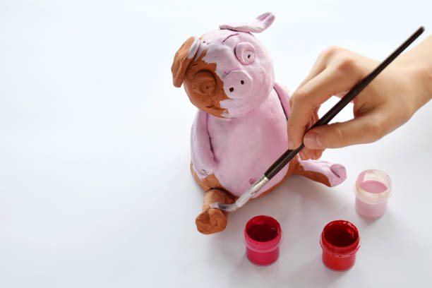 istock Making clay toy. Painting pig with gouache. Creative leisure for children. Supporting creativity, learning by doing, DIY project, hand craft. Master class of art 1071726802