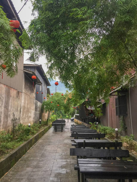 istock Walkaway view with old building, tree,  wooden table and chair covered by tree. 1071727298