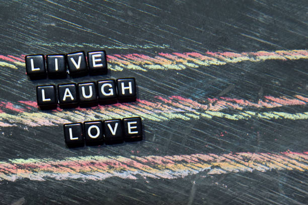 Live Laugh Love on wooden blocks. Cross processed image with blackboard background. Inspiration, education and motivation concepts