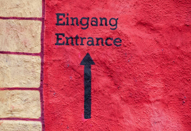 Entrance sign painted on a housewall in two languages, english and german.