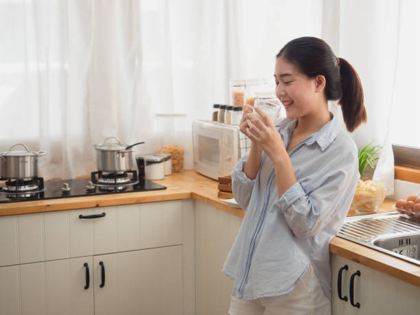 istock asian woman drink milk  in the kitchen 1071732152