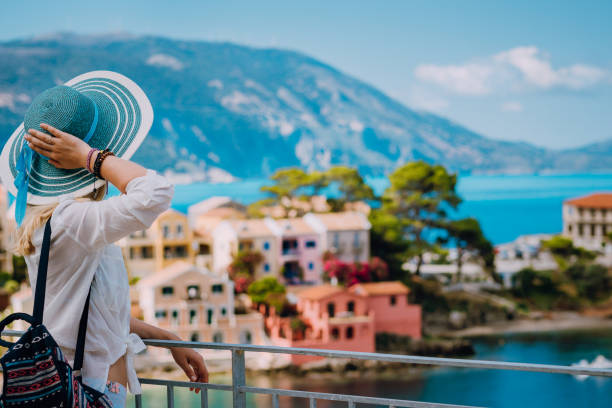 観光女性 sunhat の青と白を身に着けている晴れた日に楽しんで観カラフルな静かな村 assos の服します。スタイリッシュな女性の夏の時間でギリシャ旅行休暇にケファロニア島を訪問 - assos ストックフォトと画像