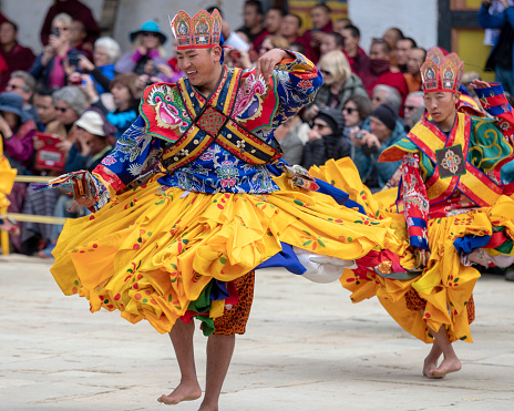 Gangtey, Bhutan - November 11, 2018: Dancers at the Gangtey Monastery in the Phobjikha Valley, Bhutan, performing in the Black-Necked Crane festival, held annually to celebrate the return of the Black-Necked Cranes from their breeding grounds in Tibet each winter.  The festival was first held in November 1998 to encourage awareness of the vulnerable status of the cranes, and has since become a popular event among both locals and tourists.