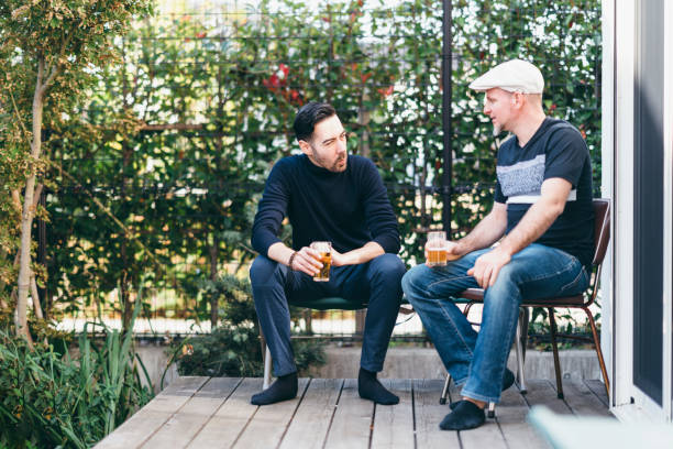 istock Two men enjoying talking to each other at home party 1071742312